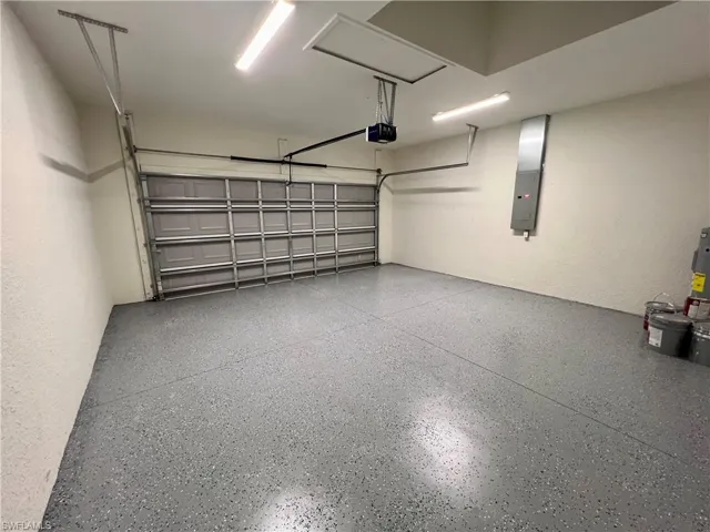 Garage featuring a garage door opener and seal coated floors.