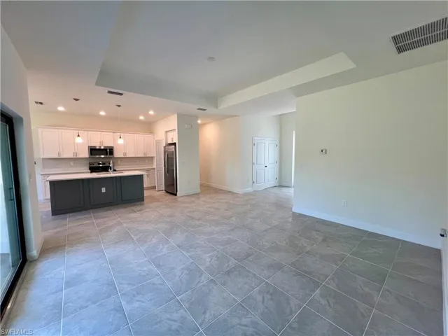 Volume ceilings in living room with tray ceiling and tile floors.