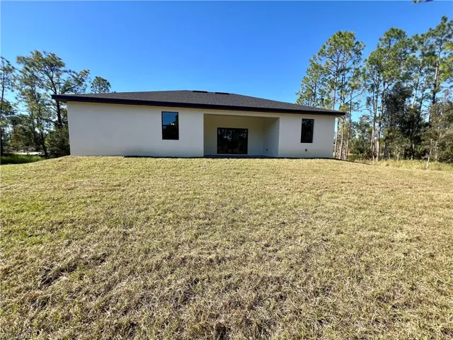 Rear view of property with a yard