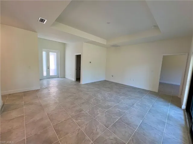 Volume ceilings in living room with tray ceiling and tile floors.