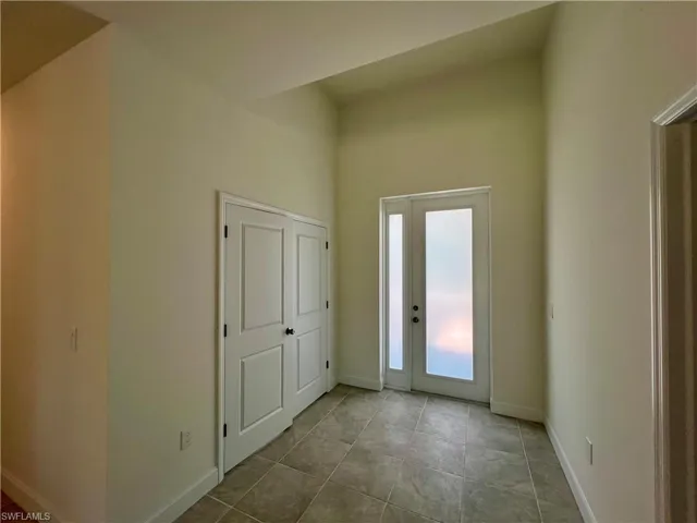 Entrance foyer featuring tile floors and French doors to the den/4th bedroom