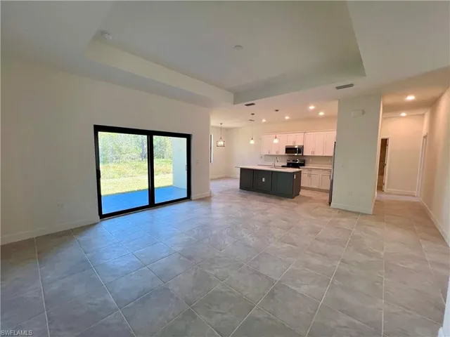 Volume ceilings in living room with tray ceiling and tile floors.