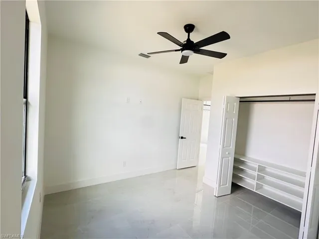Unfurnished bedroom with ceiling fan, a closet, visible vents, and baseboards
