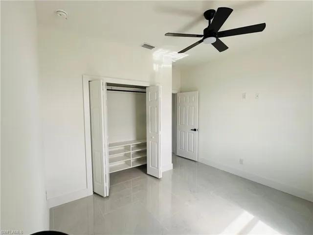Unfurnished bedroom featuring a ceiling fan, a closet, visible vents, and baseboards
