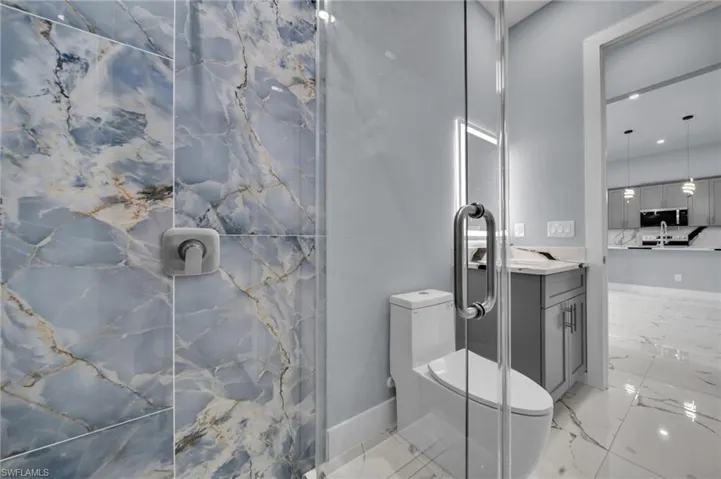 Full bathroom featuring marble finish flooring, vanity, a marble finish shower, and recessed lighting