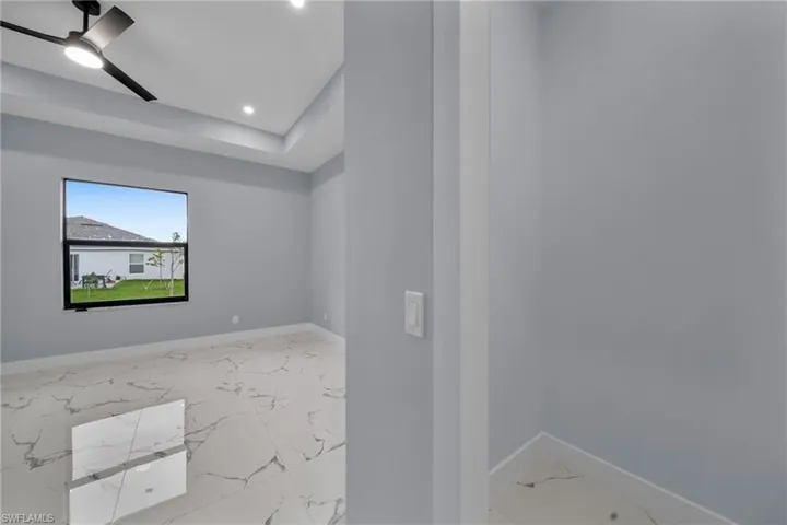 Unfurnished room featuring marble finish floors, ceiling fan, and recessed lighting