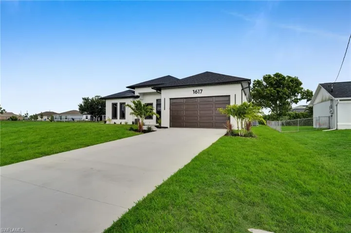 View of front of home with a garage, stucco siding, and concrete driveway
