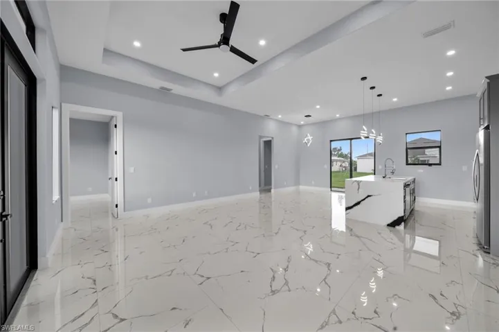 Unfurnished living room featuring ceiling fan, recessed lighting, and light marble finish floors