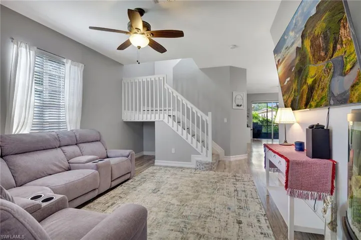 Living room with light wood-type flooring and ceiling fan