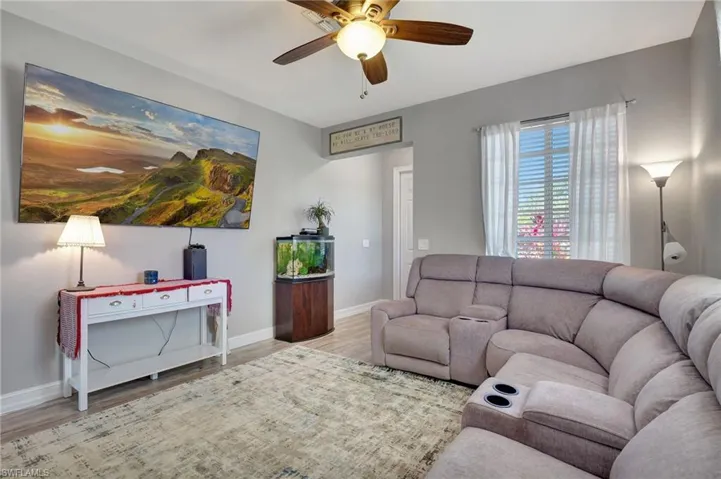 Living room with ceiling fan and light hardwood / wood-style flooring
