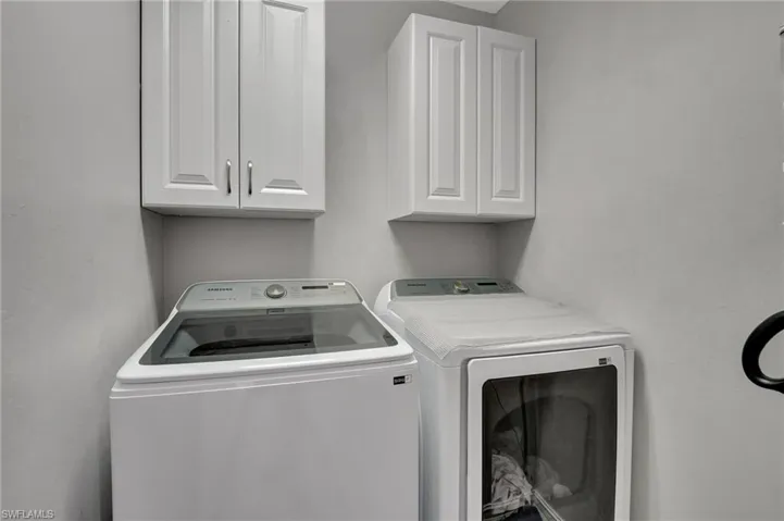 Laundry area featuring cabinets and washer and clothes dryer