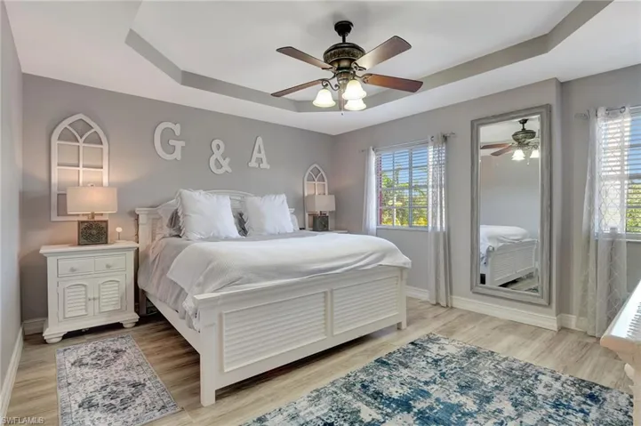 Master Bedroom with a tray ceiling, ceiling fan