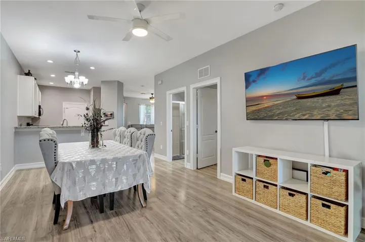 Dining room with ceiling fan with notable chandelier