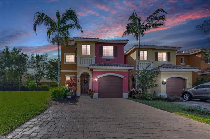 Mediterranean / spanish-style home featuring a garage and a yard