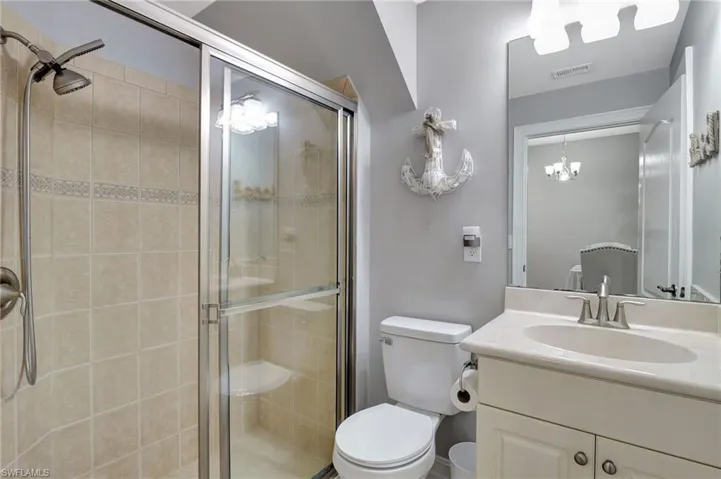 Downstairs Bathroom with vanity, toilet, a shower with shower door