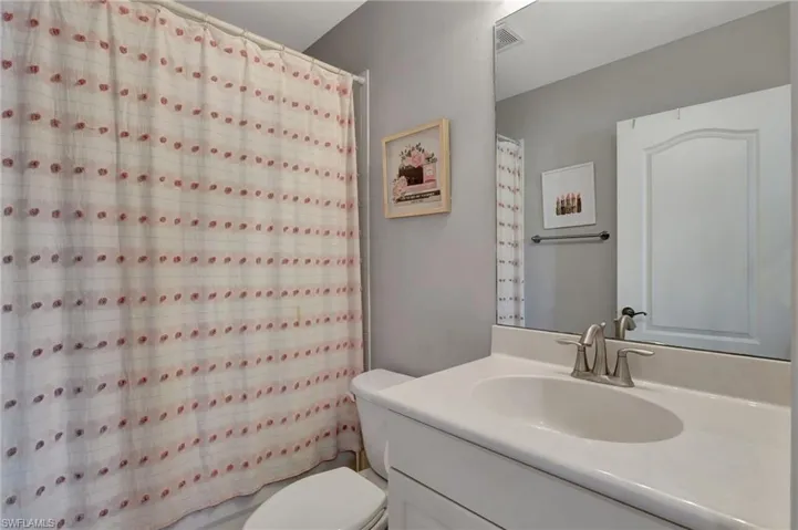 Upstairs Bathroom featuring vanity, curtained shower, and toilet