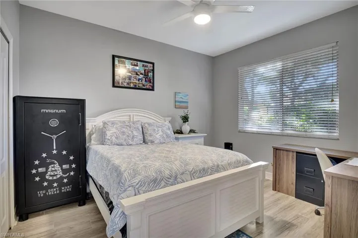 Downstairs Bedroom with light wood-type flooring and ceiling fan