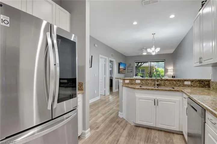 Kitchen with white cabinets, sink, appliances with stainless steel finishes, and kitchen peninsula