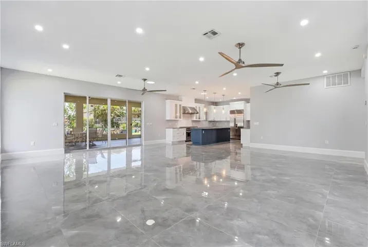 Spacious open-concept living area featuring large format tile flooring and recessed lighting