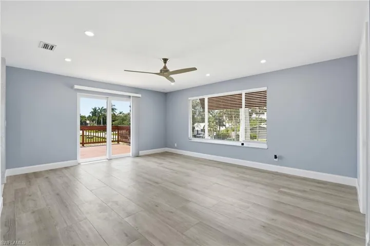 Spacious room featuring light wood-finish flooring, recessed lighting, and a ceiling fan