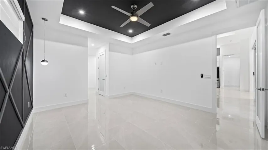 Spare room with a tray ceiling, recessed lighting, and a ceiling fan
