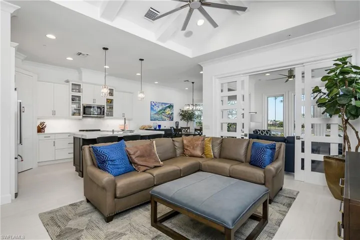 Living room featuring ceiling fan, views of the kitchen and Sun Room.