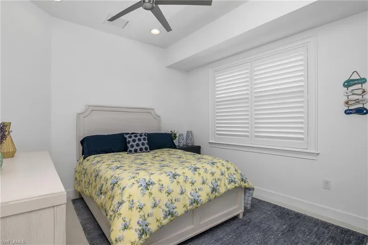 Guest Bedroom featuring ceiling fan, Plantation Shutters, Plank Style flooring.