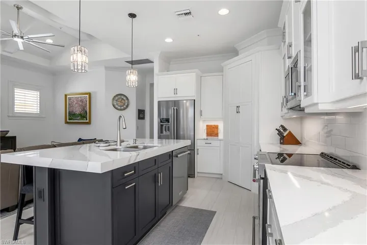 Kitchen with white cabinetry, stainless steel appliances, and an island.