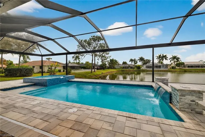 View of swimming pool with a lanai, a pool with connected hot tub, a sunroom, a water view, and a residential view