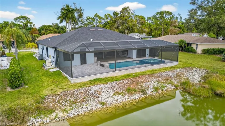 Back of house featuring glass enclosure, a yard, a sunroom, and an outdoor pool