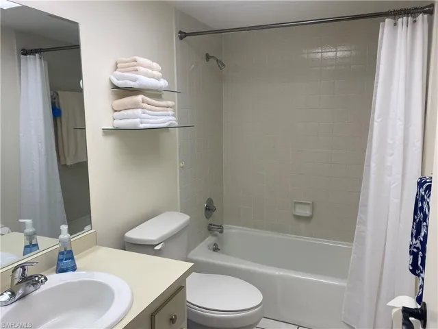 Full bathroom featuring shower / tub combo with curtain, vanity, and toilet