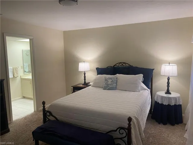 Carpeted bedroom featuring ensuite bath