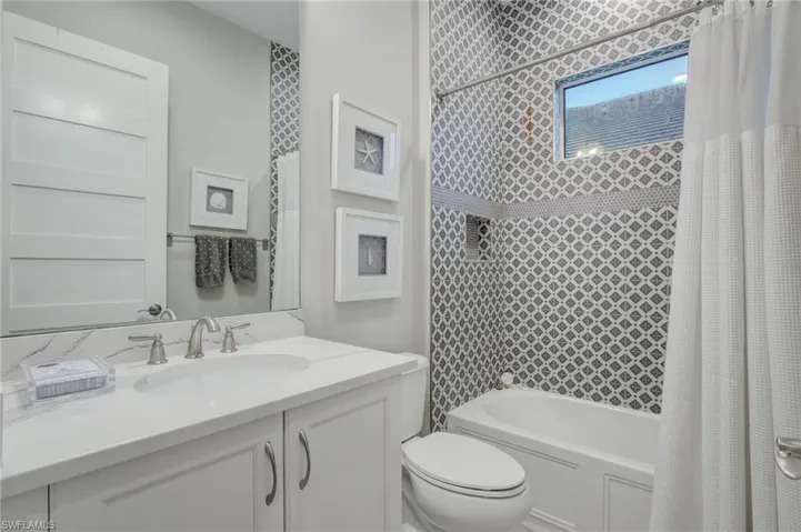 Full bathroom featuring shower / bathtub combination with curtain, toilet, and large vanity
