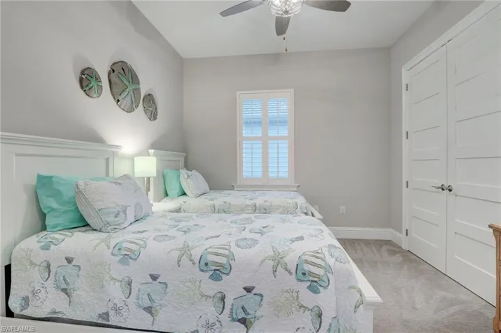 Carpeted bedroom with a closet and ceiling fan