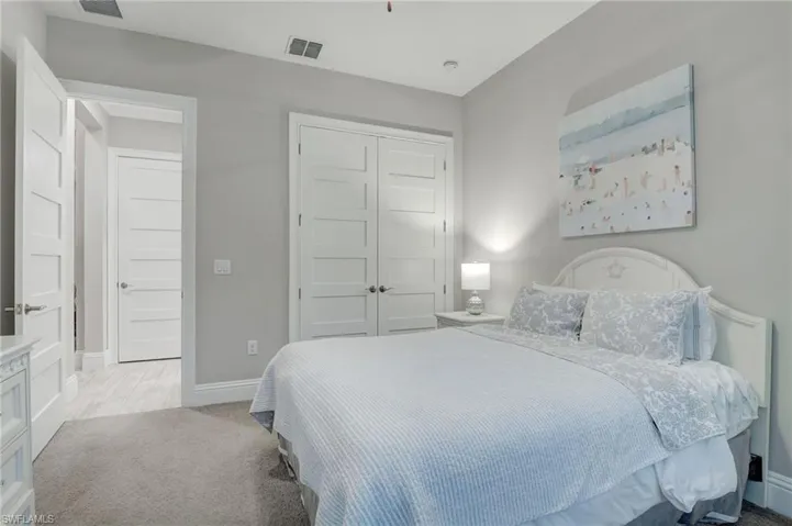 Bedroom with a closet and light colored carpet