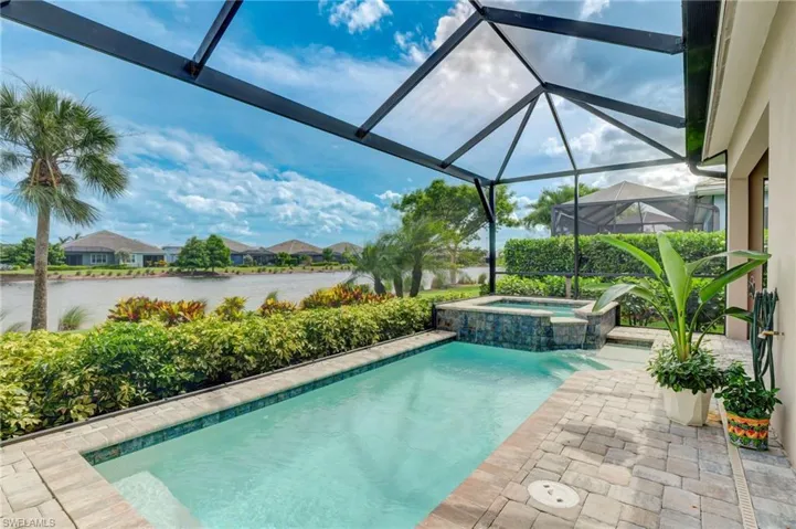View of pool with a lanai and an in ground hot tub