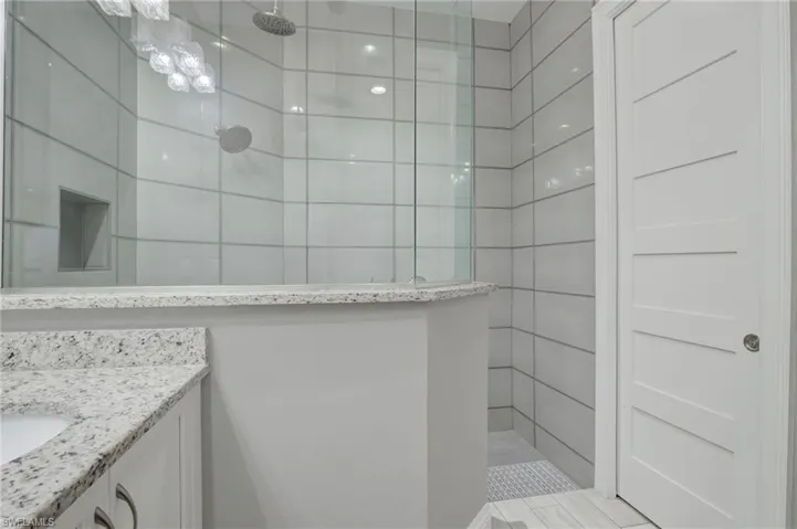 Bathroom with tiled shower and vanity