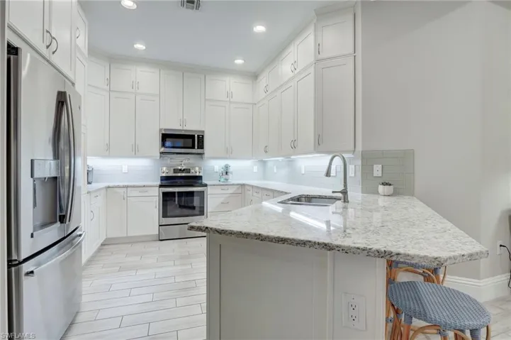 Kitchen featuring sink, backsplash, kitchen peninsula, and stainless steel appliances