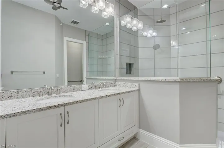 Bathroom featuring vanity with extensive cabinet space and dual sinks