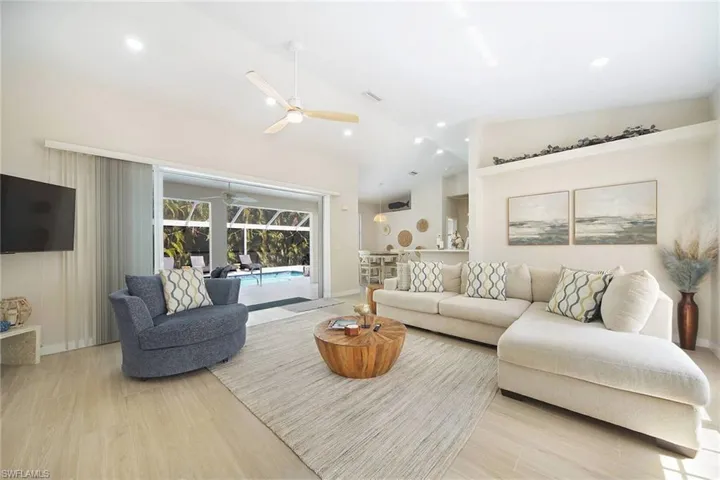 wide open great room design looking straight through tall sliders to the pool