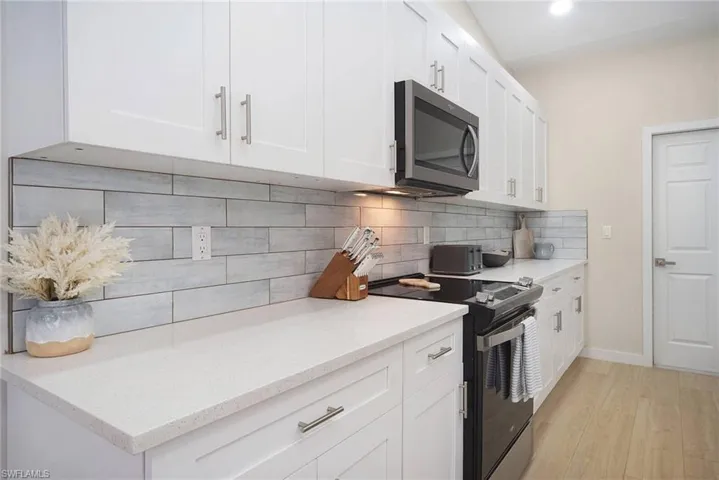 breezy blue tiled back splashed offset the ice quartz countertops