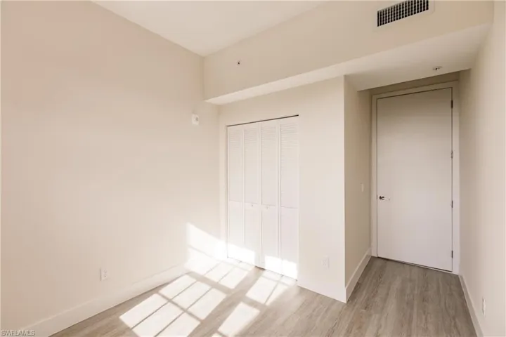 Primary bedroom with light vinyl plank floors
