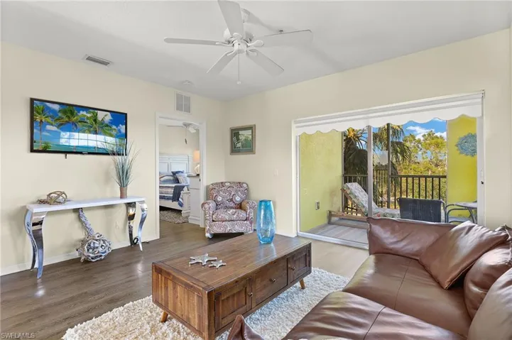 Living room featuring ceiling fan and dark hardwood / wood-style flooring