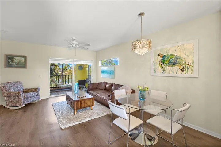 Living room featuring wood-type flooring and ceiling fan with notable chandelier