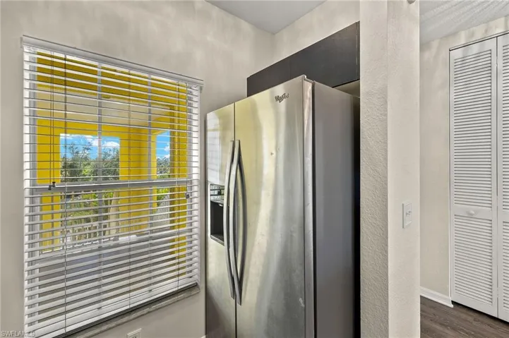 Kitchen with stainless steel fridge and dark hardwood / wood-style flooring