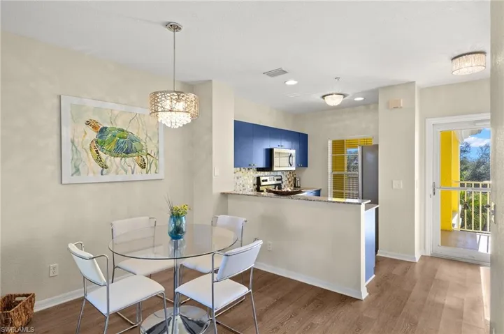 Dining room with dark hardwood / wood-style floors and a notable chandelier
