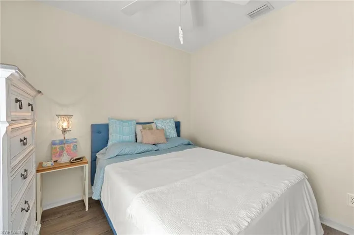 Bedroom with ceiling fan and dark hardwood / wood-style flooring
