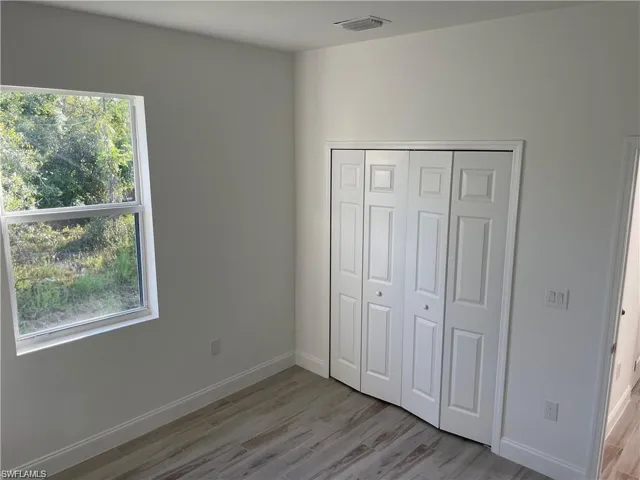Unfurnished bedroom featuring light hardwood / wood-style floors and a closet