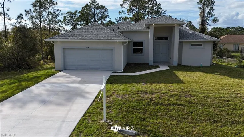 View of front of property featuring a front lawn and a garage