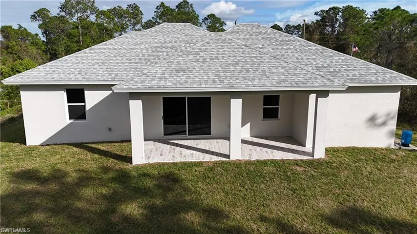 Back of house featuring a lawn and a patio